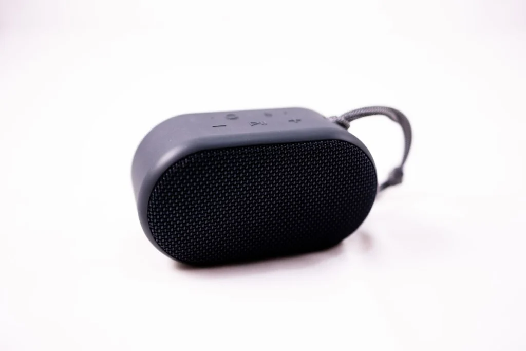 Compacte draagbare bluetooth-speaker met polsband op witte achtergrond