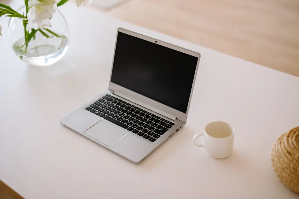 Laptop met geopend scherm op een minimalistisch wit bureau